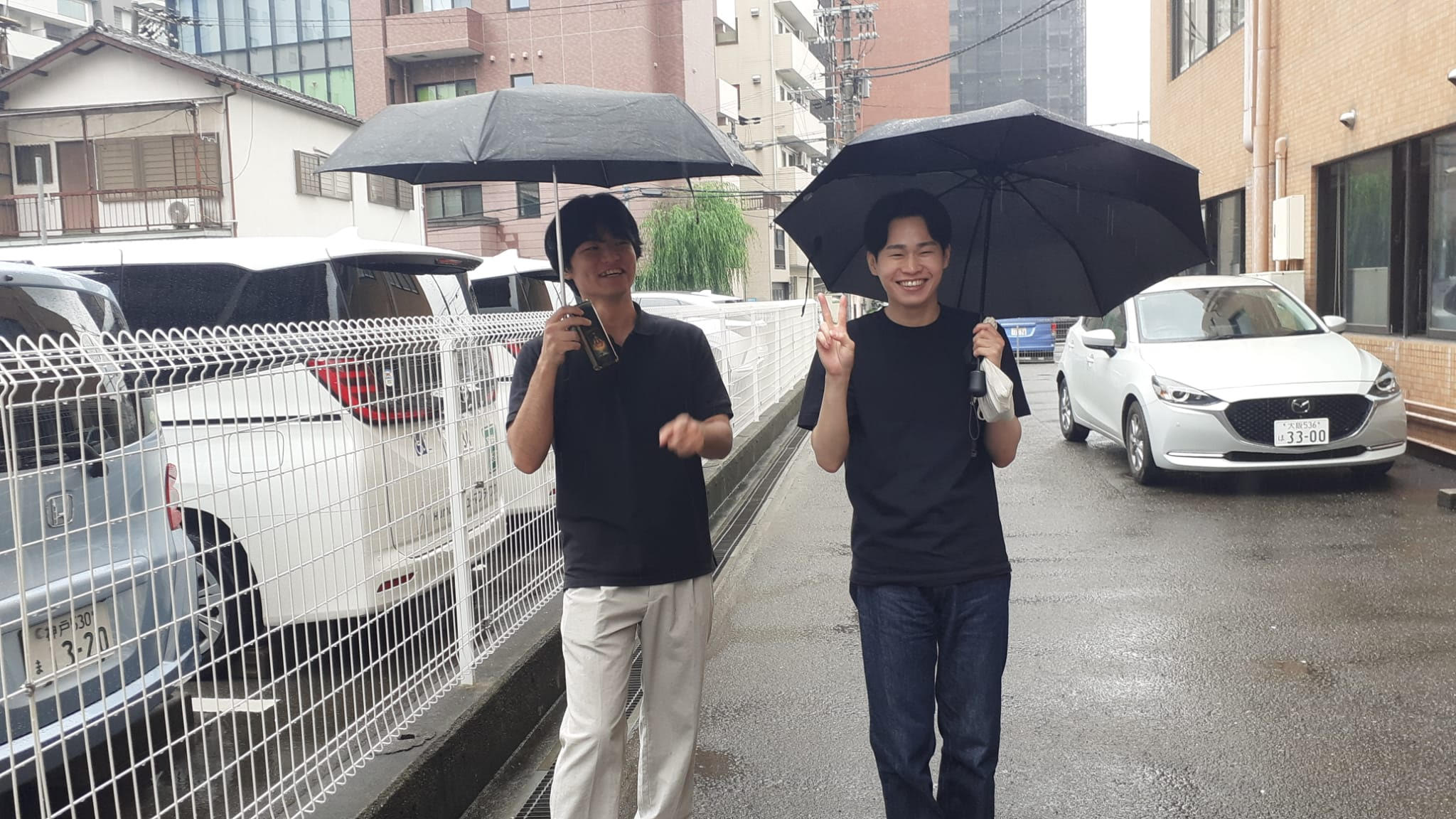 Zwei junge Männer helfen beim Finden des Bridgeclubs in Osaka